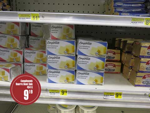 Des livres de beurre salé et demi-sel de marque Lactancia et Compliments reposent sur un étalage. Une étiquette précise le prix de vente de 9,19 $ la livre.